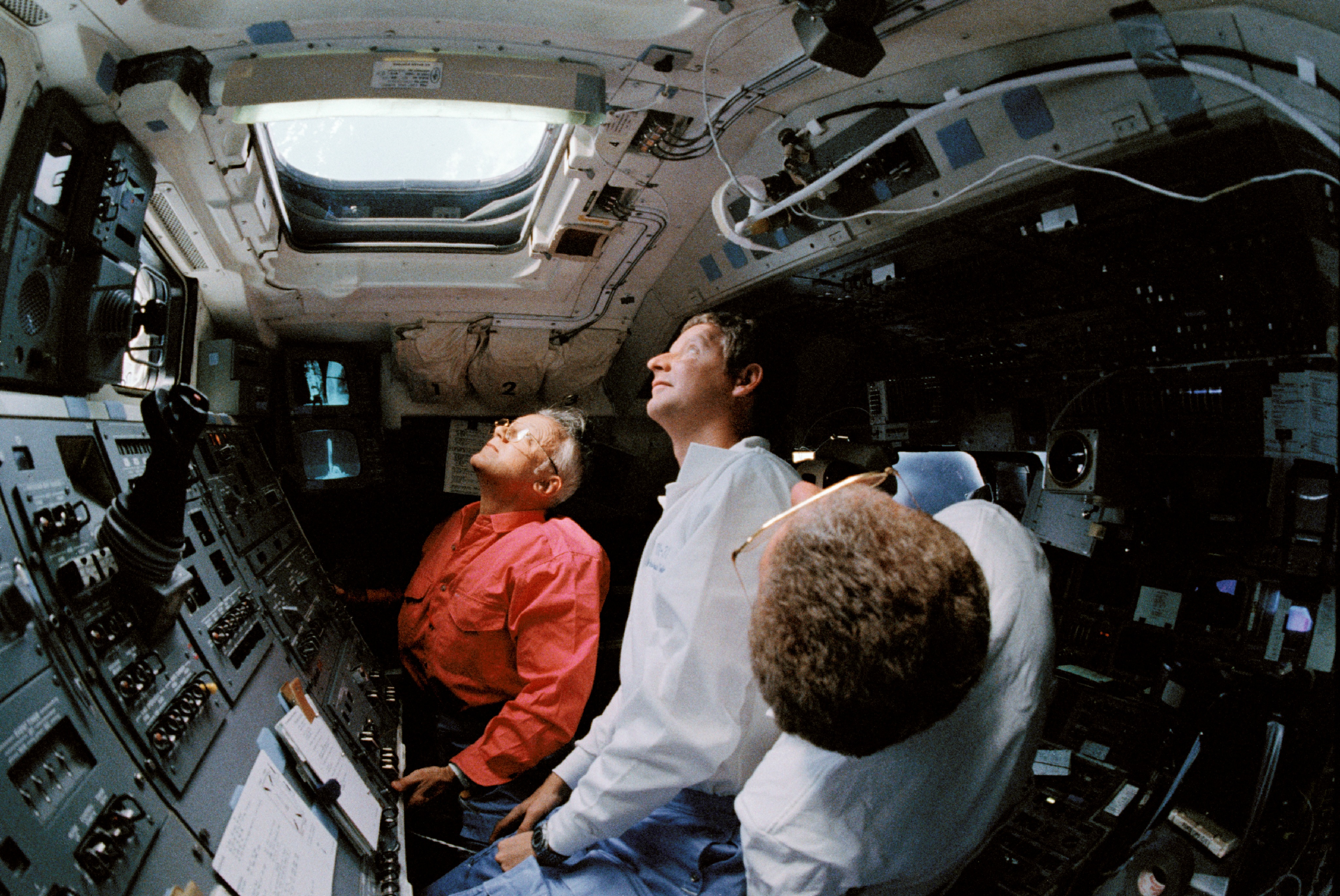 Astronauts Loren J. Shriver, Steven A. Hawley and Bruce McCandless II watch the deployment of the Hubble Space Telescope from the aft flight deck of Space Shuttle Discovery 25 April 1990.jpg