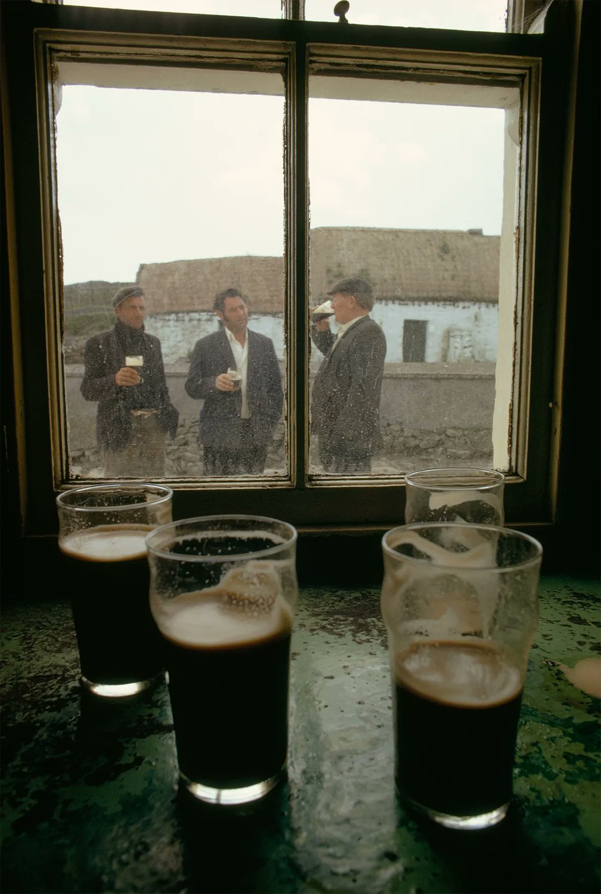 Livestock traders drink outside the only pub on Inis Meáin, off the west coast of Ireland, 1971.jpg