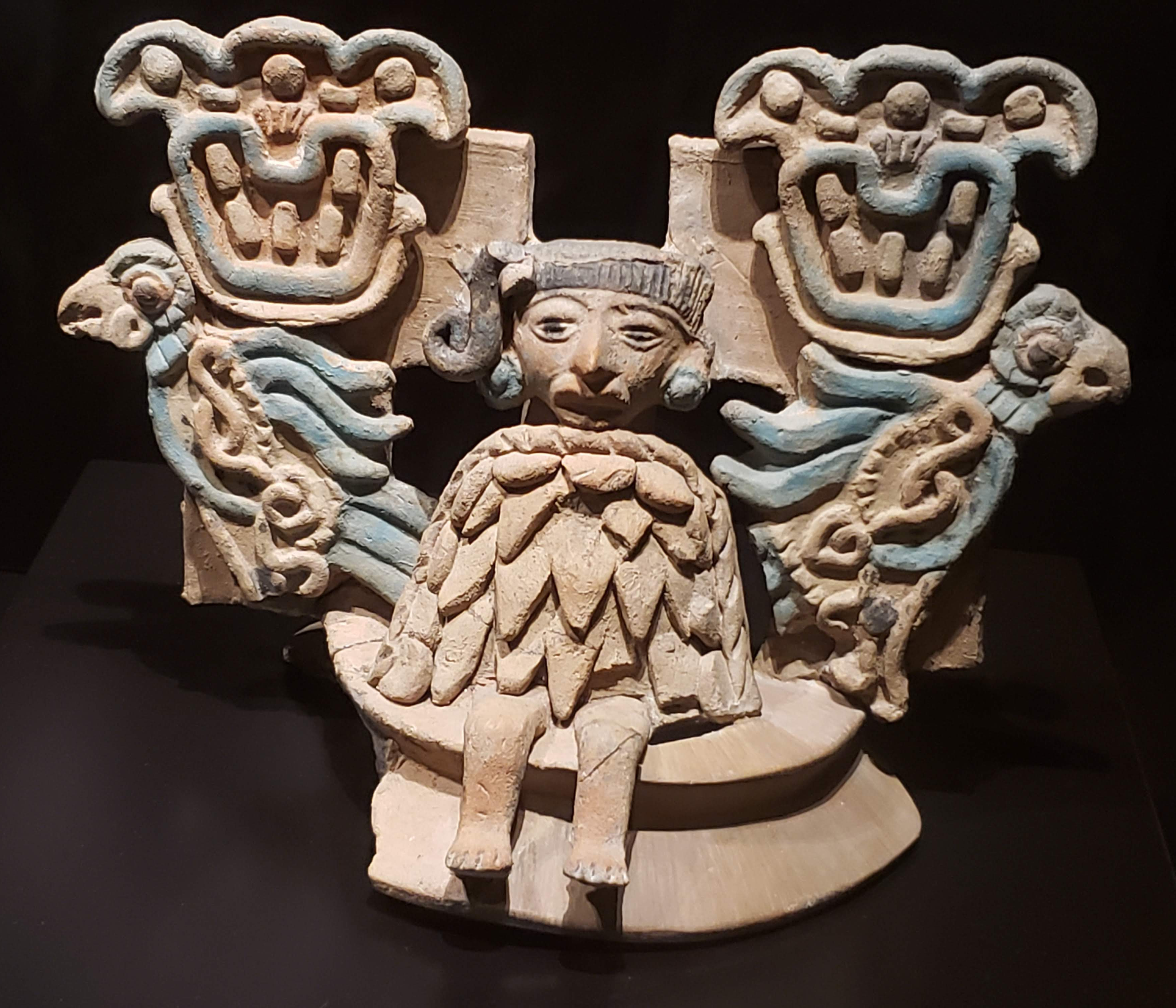 Painted ceramic censer cover with seated figure flanked by two birds, on which two glyphs appear. Teotihuacán, Xolalpan phase, ca. 400-650 AD. Museo de América, Madrid.jpg