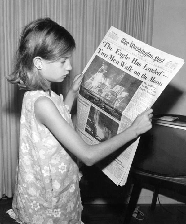 On July 21, 1969, a girl holds a copy of The Washington Post, whose headline reads The Eagle Has Landed - Two Men Walk on the Moon..jpg