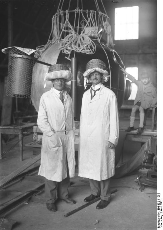 Auguste Piccard & Paul Kipfer became the first humans to reach the stratosphere wearing these improvised crash helmets. And the metal ball behind them is what they rode in. 1931.jpg