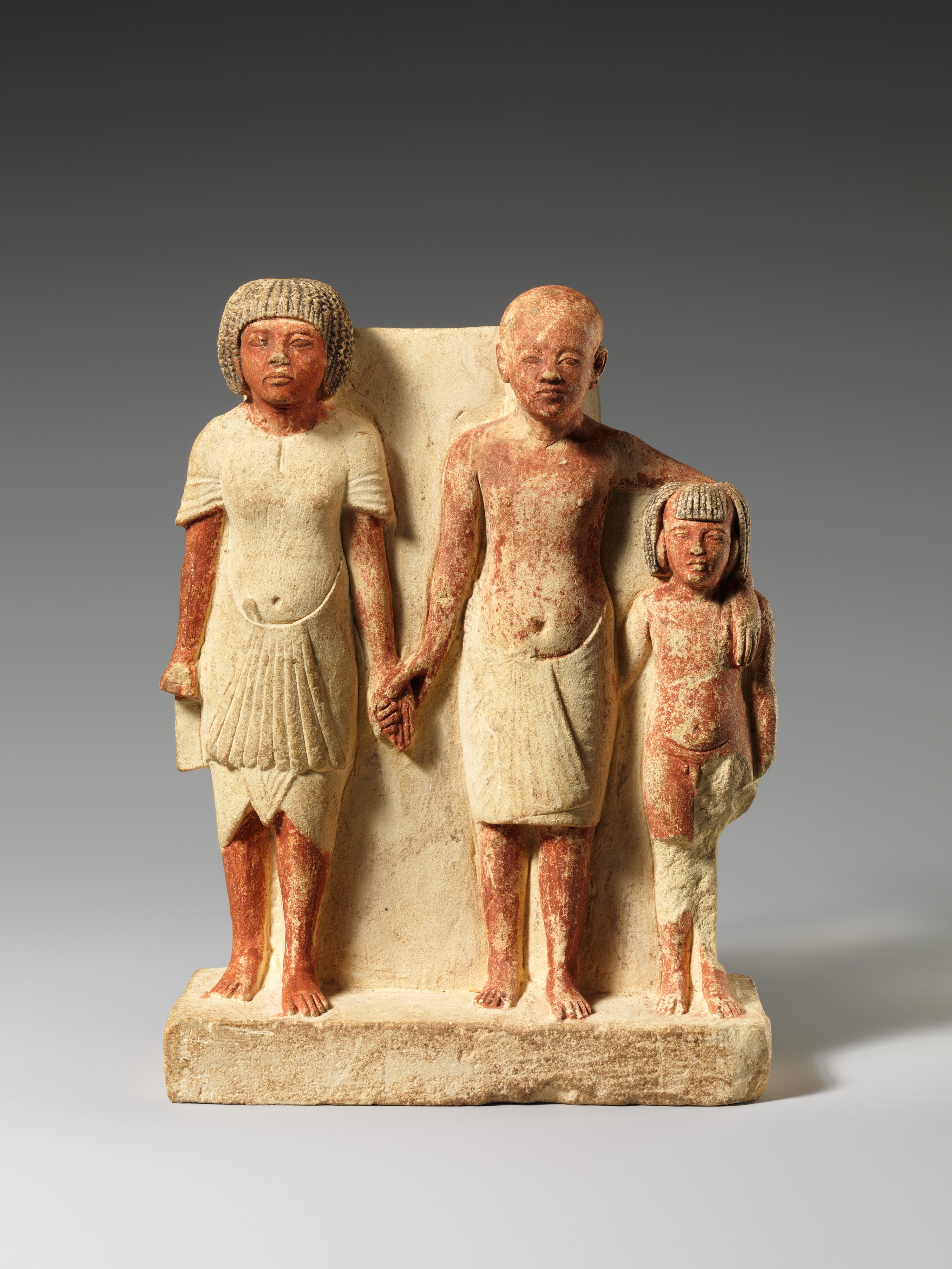 Painted limestone statue with a higher status man at left, a lower status man and a boy. New Kingdom Egypt, Amarna period, reign of Akhenaten, ca 1353-1336 BC. Metropolitan Museum of Art collection.jpg