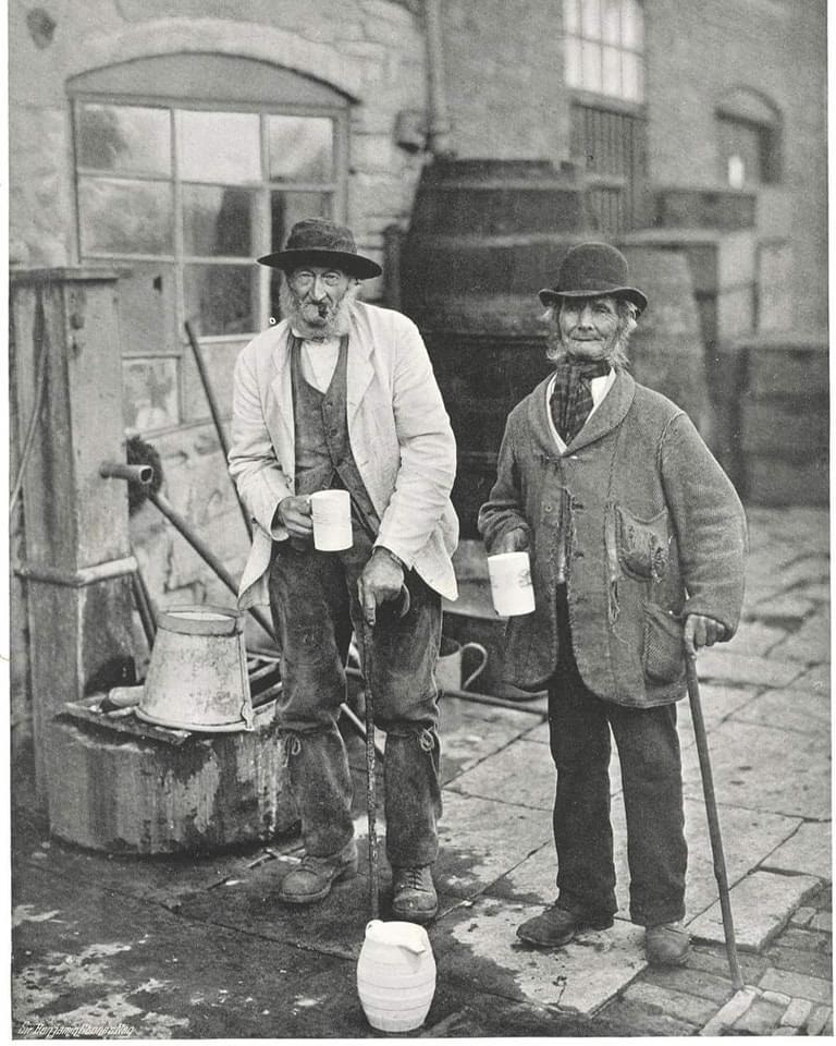 Two villagers drinking at the Bidford Mop annual fair in the village of Bidford-on-Avon in the English county of Warwickshire, circa 1900.jpg