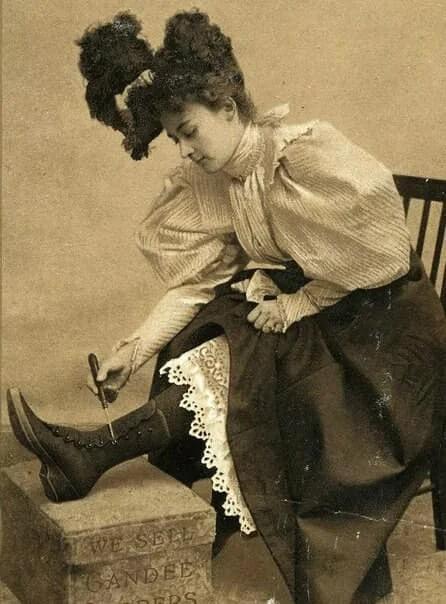 Woman buttons up her boots 1895.jpg