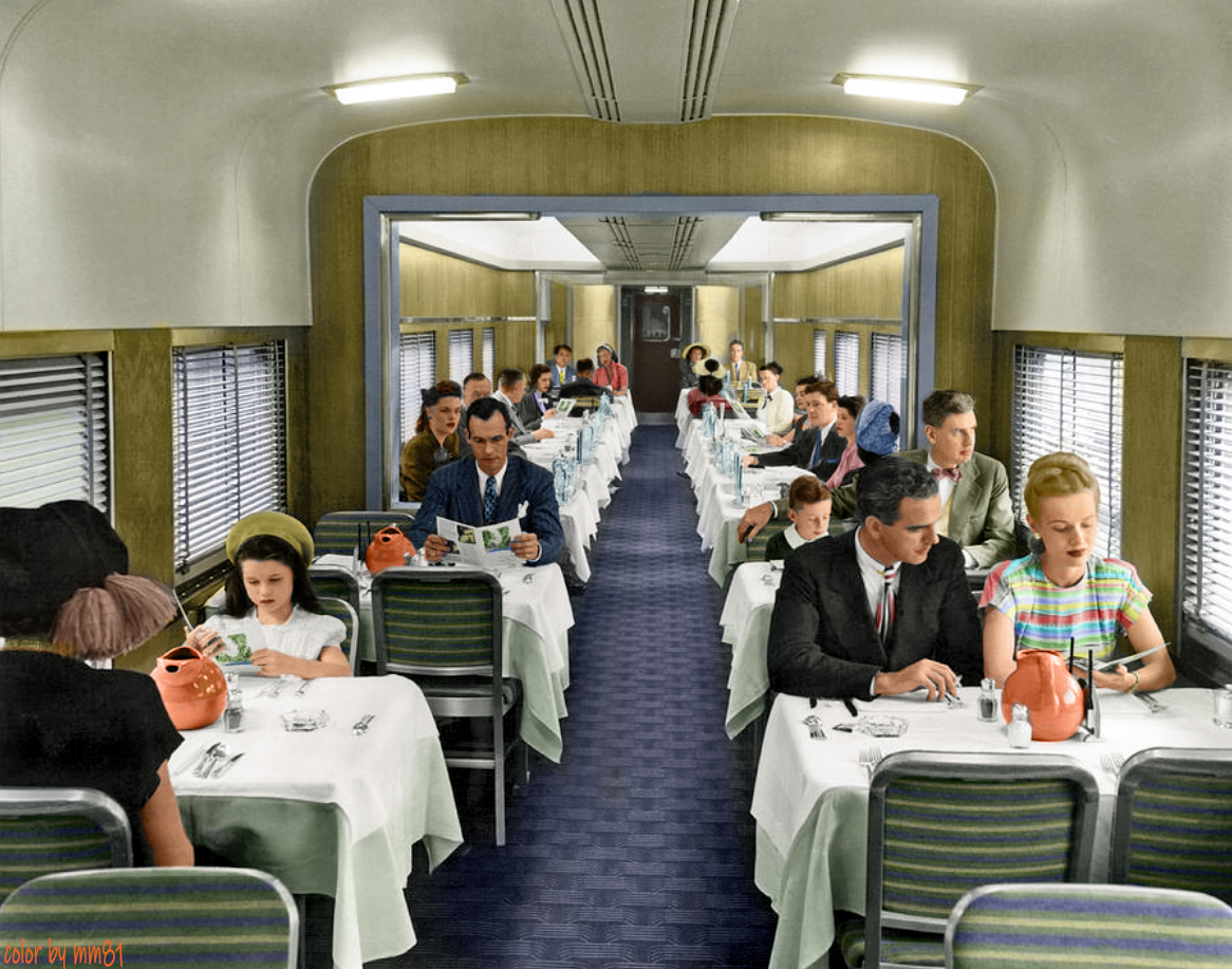 Train passengers in a dining car having dinner in the United States, c. 1940. (Colorized by OP).png