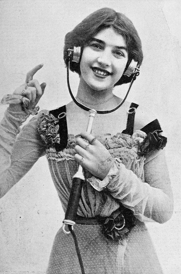A young woman showing off an electrophone that could broadcast plays and concerts over the telephone line, c. 1901.jpg
