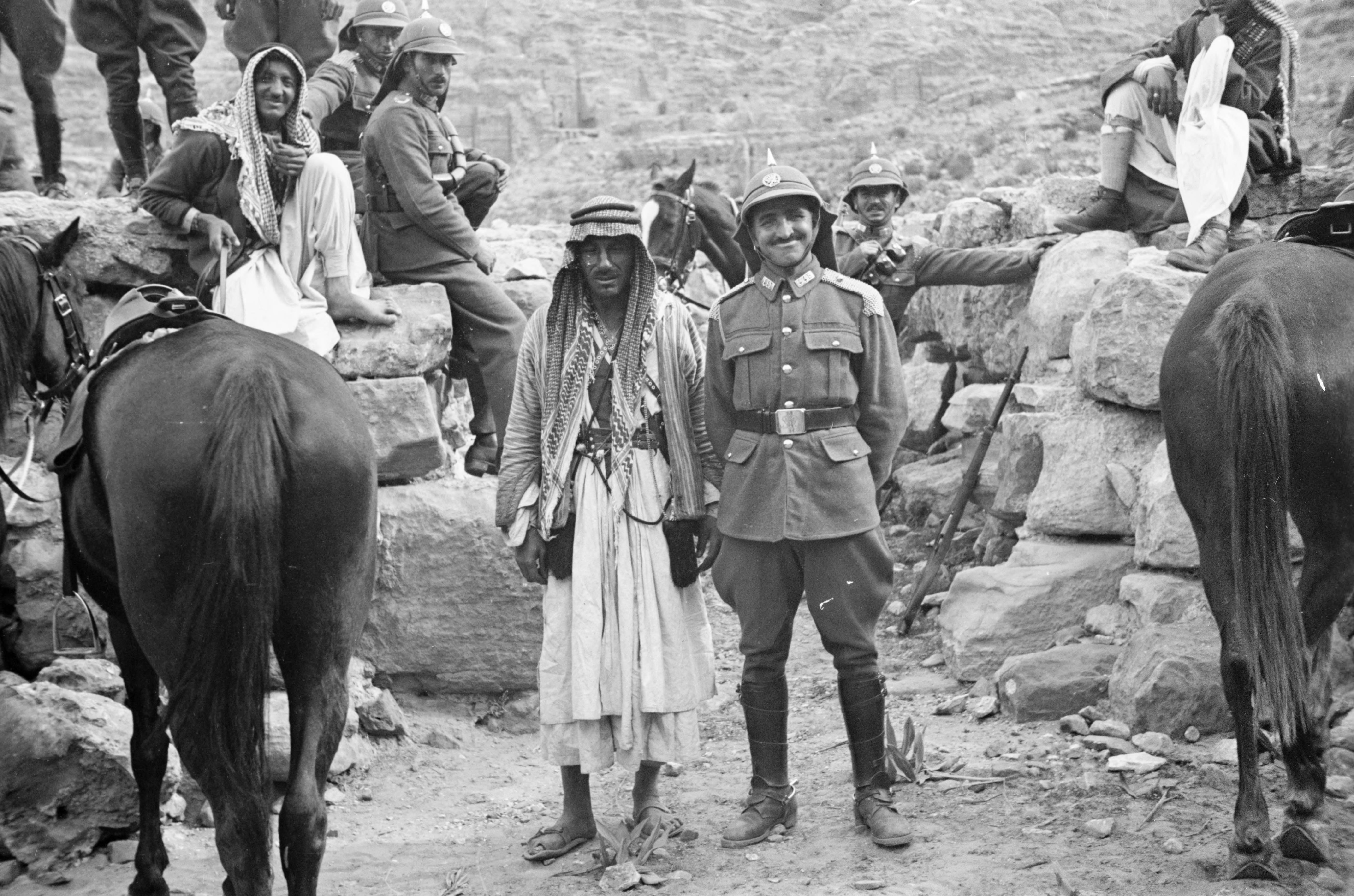 A group of the Crown Prince’s guards and some locals, some of them smiling cheesily, pose for a photo. Petra, southern Jordan, 1930s..jpg