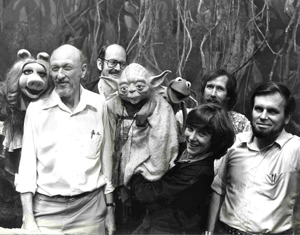 Mullen manipulates Yoda on the set of The Empire Strikes Back with Frank Oz as Miss Piggy, director Irvin Kershner, Jim Henson as Kermit the Frog, and Gary Kurtz.jpg