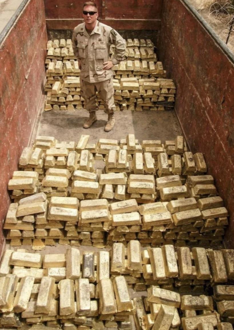 American soldier standing in a truck loaded with gold recovered from Saddam Hussein - Iraq, 2003.jpg
