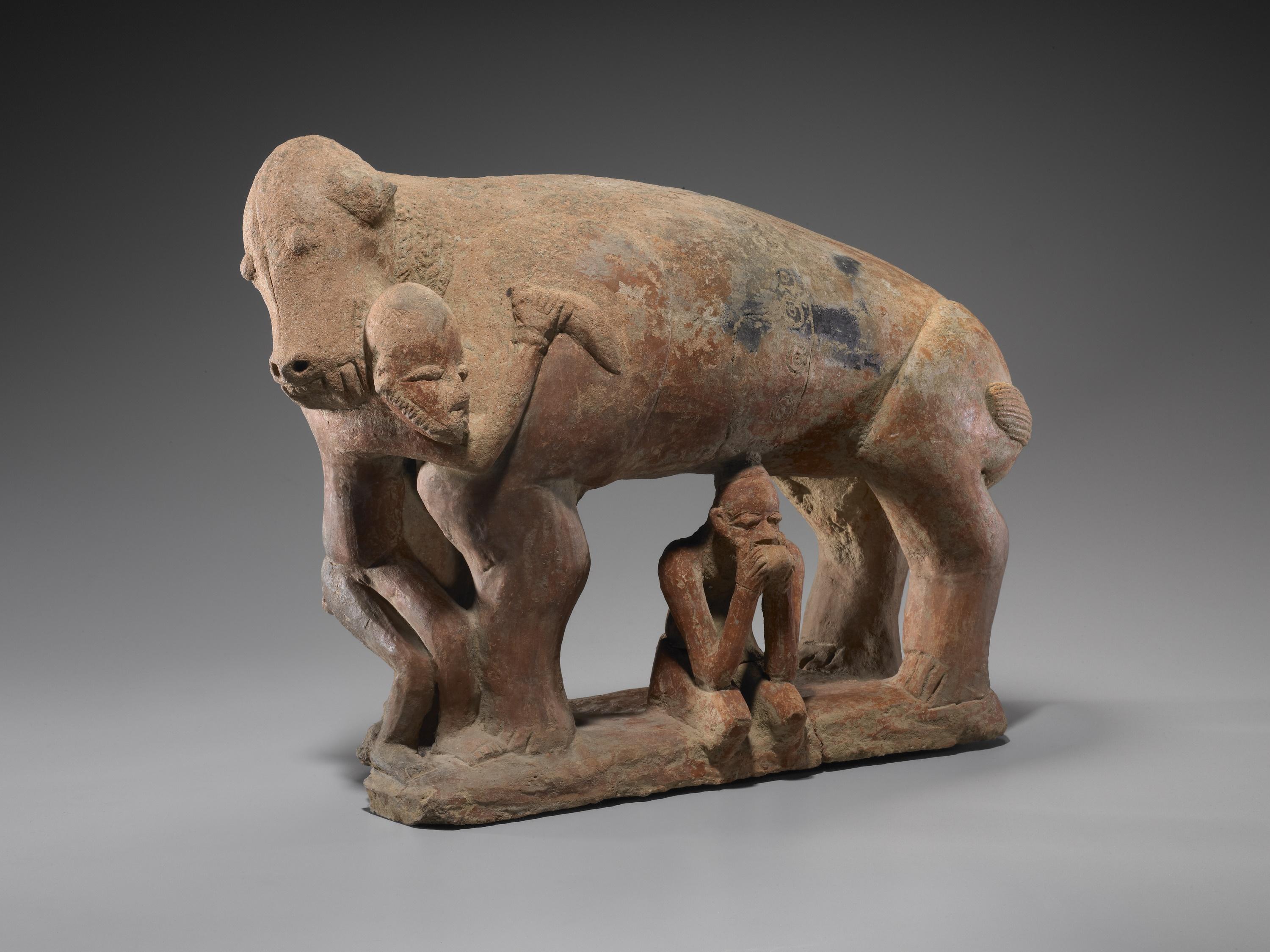Terracotta sculpture of a fanged quadruped engaged in combat with one human figure while another sits in a contemplative pose underneath its body. Jenne-Jeno culture, Mali, 12th-15th c..jpg