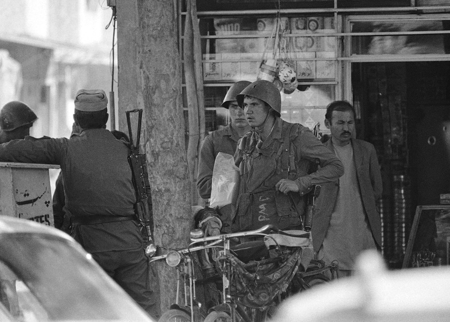 Two Soviet Army soldiers emerge from an Afghan shop in downtown Kabul on April 24, 1988. AP Photo, Liu Heung Shing.jpg