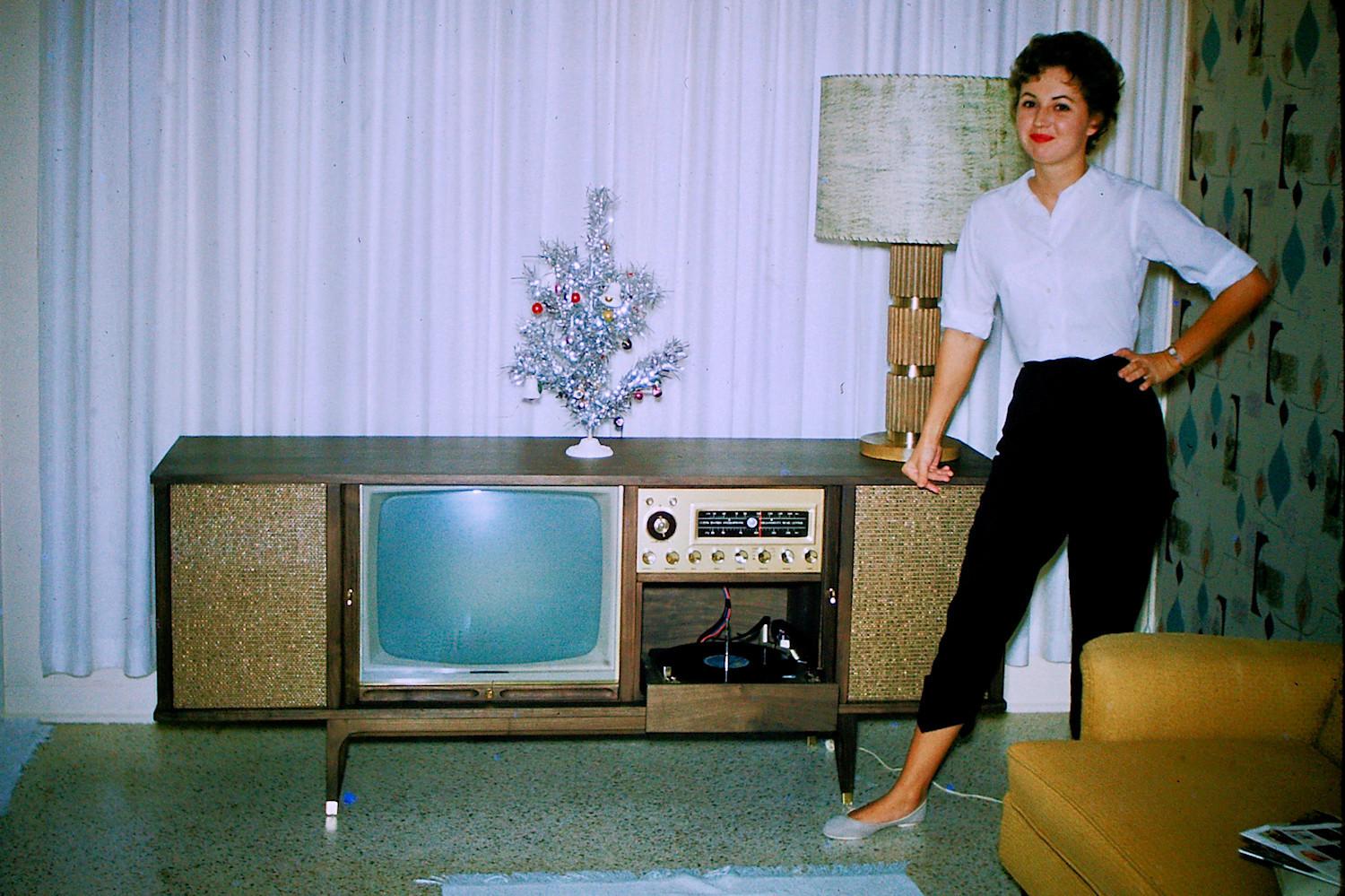 Ticks all the boxes... TV console, aluminum X-mas tree, funky wallpaper, capri pants. Welcome to the early 1960s.jpg