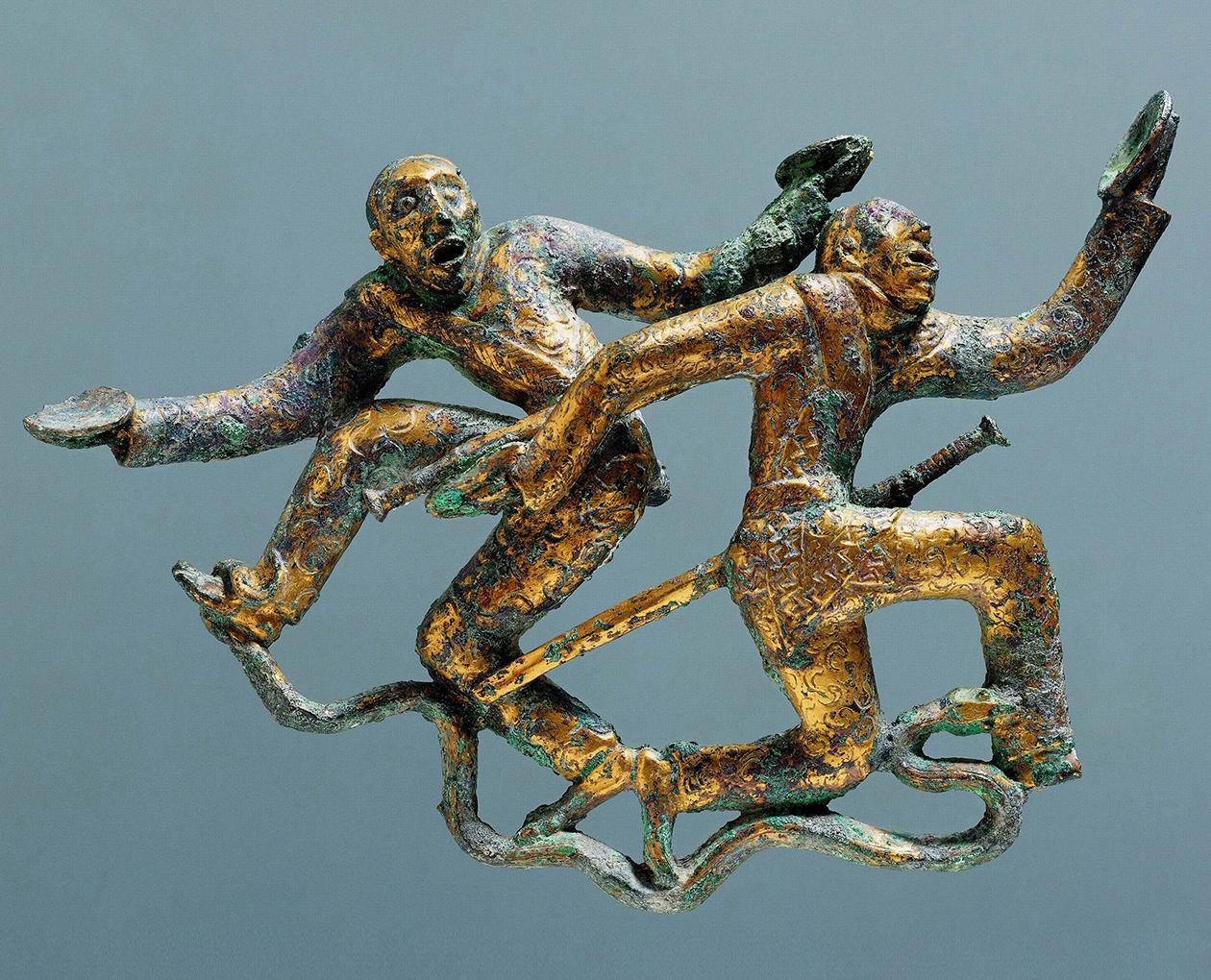 Bronze ornament of two men dancing on a snake while holding cups. China, Han dynasty, 2nd century BC.jpeg