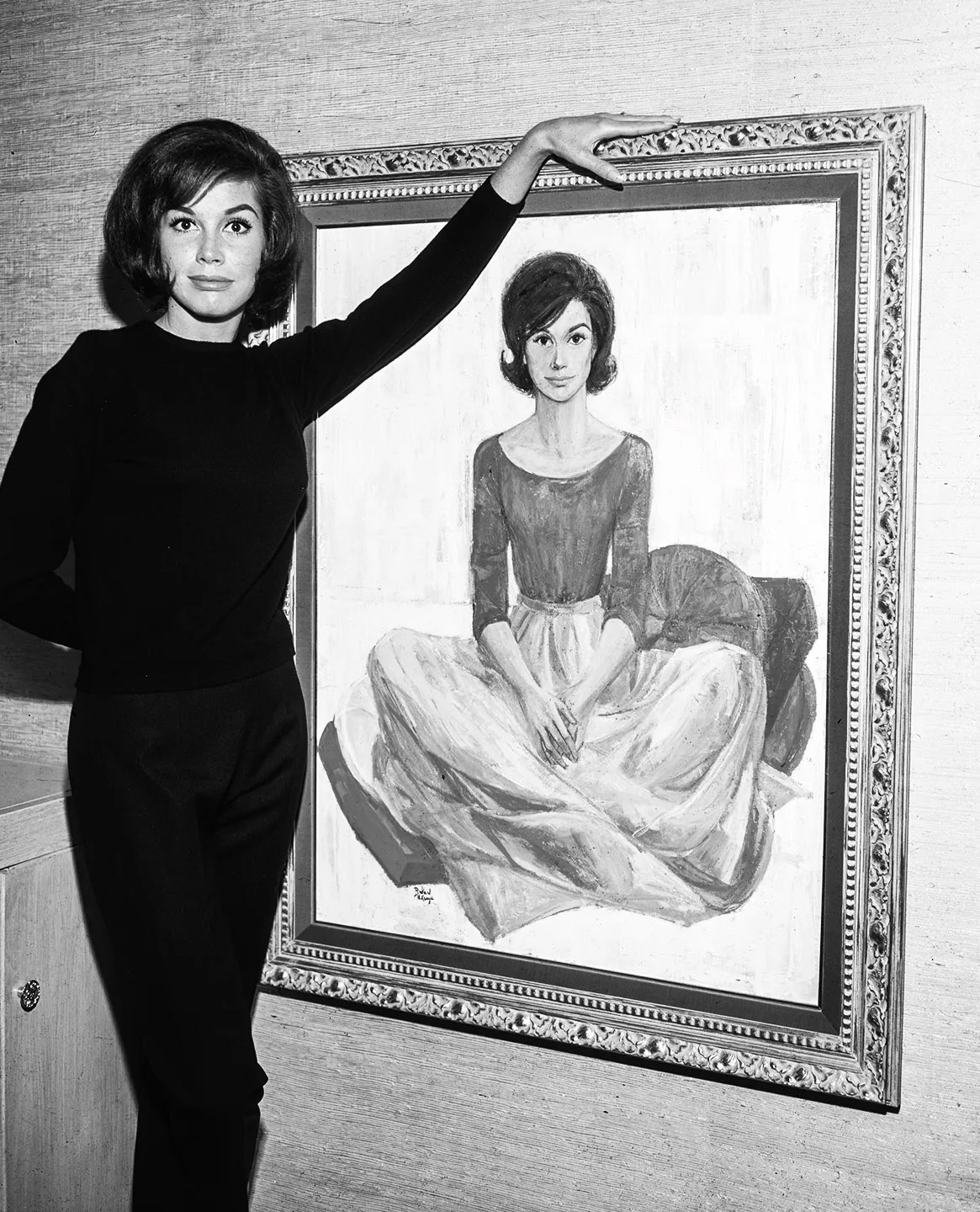 Mary Tylor Moore posing with a painting of herself, circa 1970s.jpg
