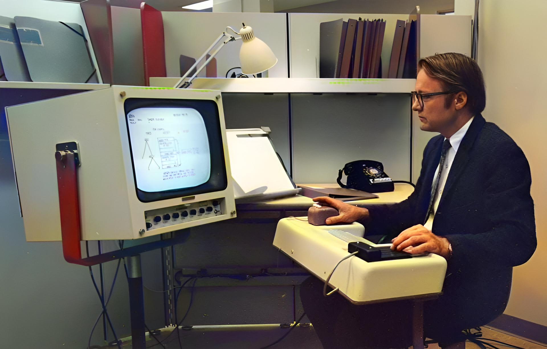 Operating a computer using a mouse and a monitor, 1968, colourised.jpeg