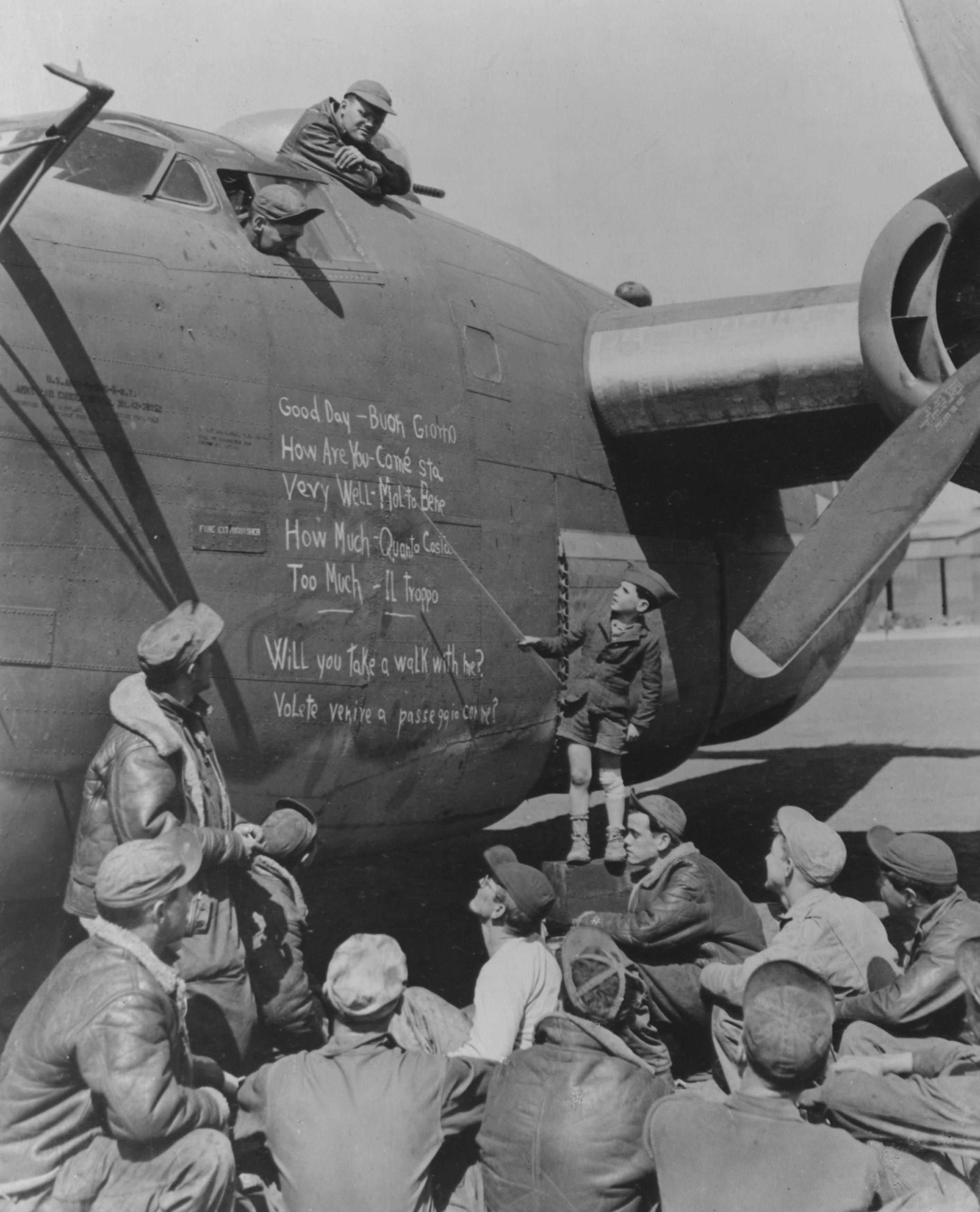 USAAF airmen learning the local language from a young teacher using the side of a B-24 bomber as a blackboard in Southern Italy in 1944.jpeg