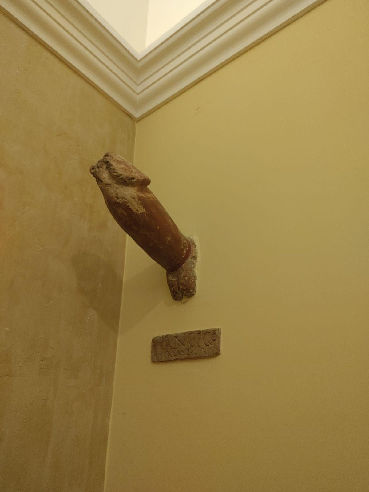 Preserved object that was attached to the wall above the entrance to a shop in Pompeii. The artifact is located in the National Archaeological Museum of Naples.jpeg