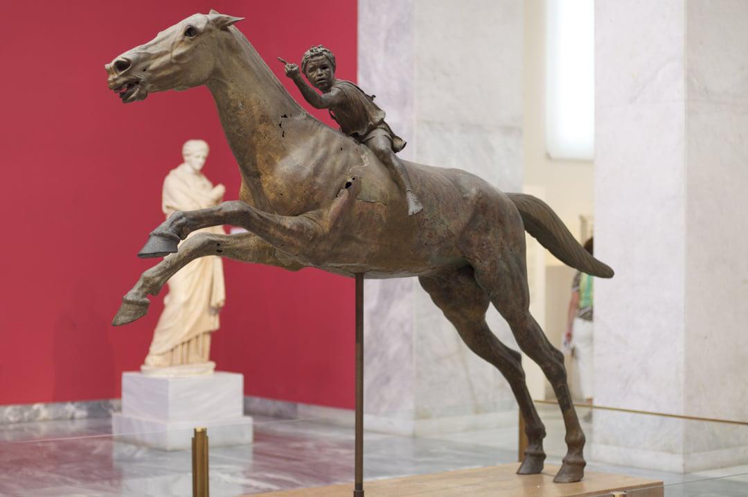 The Jockey of Artemision is a large Hellenistic bronze statue of a young boy riding a horse, dated to around 150–140 BC.jpeg