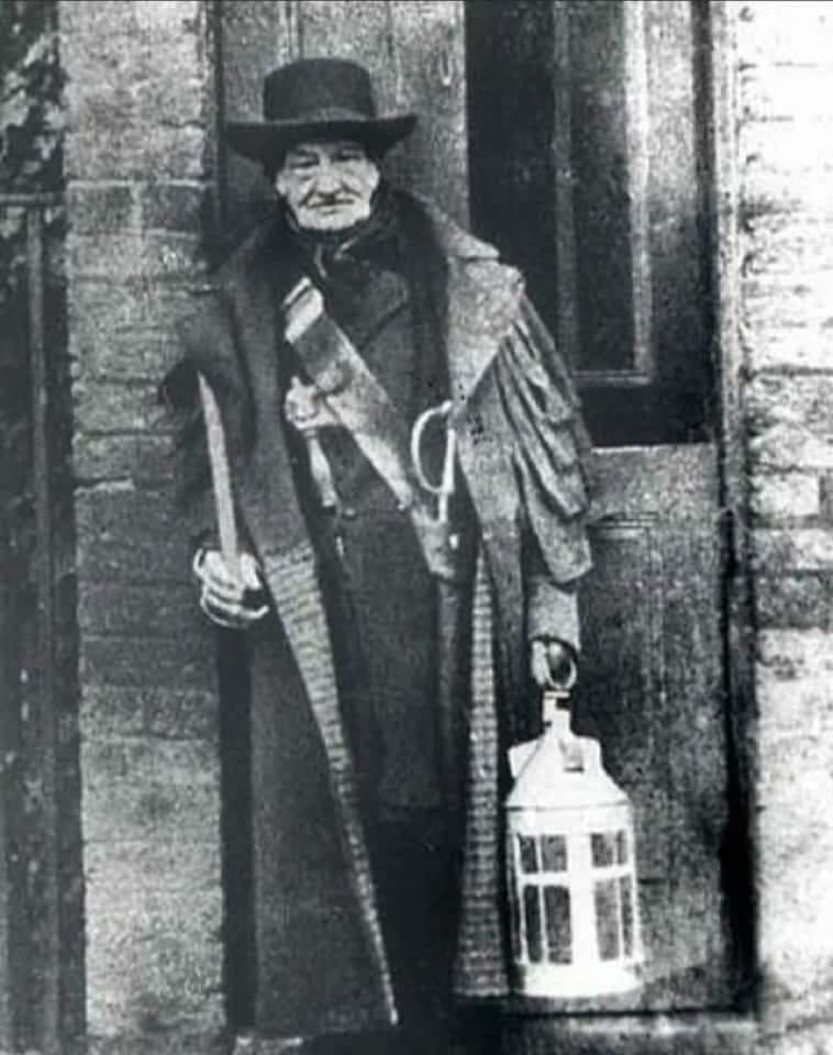 Charlie Rouse , one of London’s last night watchman armed with rattle, carrying the traditional lantern, outside his post on the Brixton Road, London in 1850.jpeg