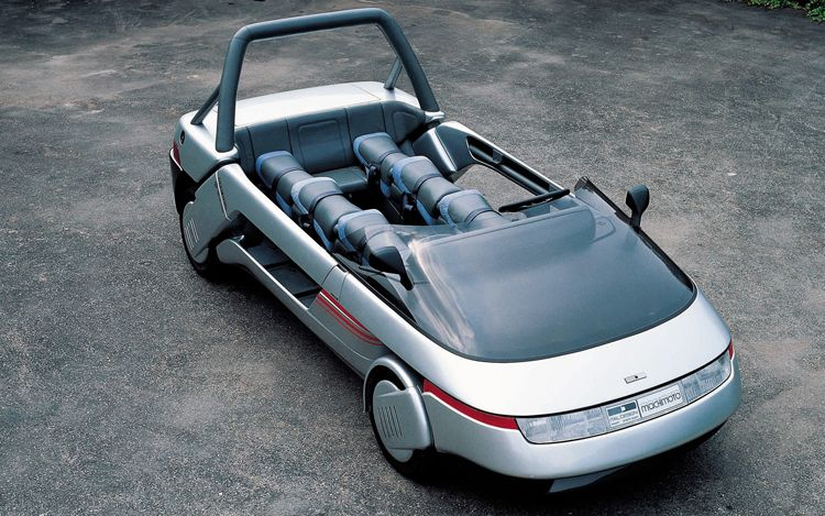 1986 Machimoto. A fusion of car & motorcycle built on a Golf platform & engine. 6 motorcycle seats combining the idea of a social car and a sand buggy.png