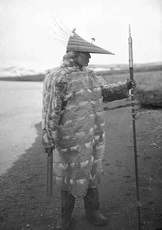 Unangax̂ (Aleut) hunter, Ivan Suvorov wearing a gut parka with a large harpoon, Umnak Island, Aleutian Islands, Alaska, c. 1909.jpeg
