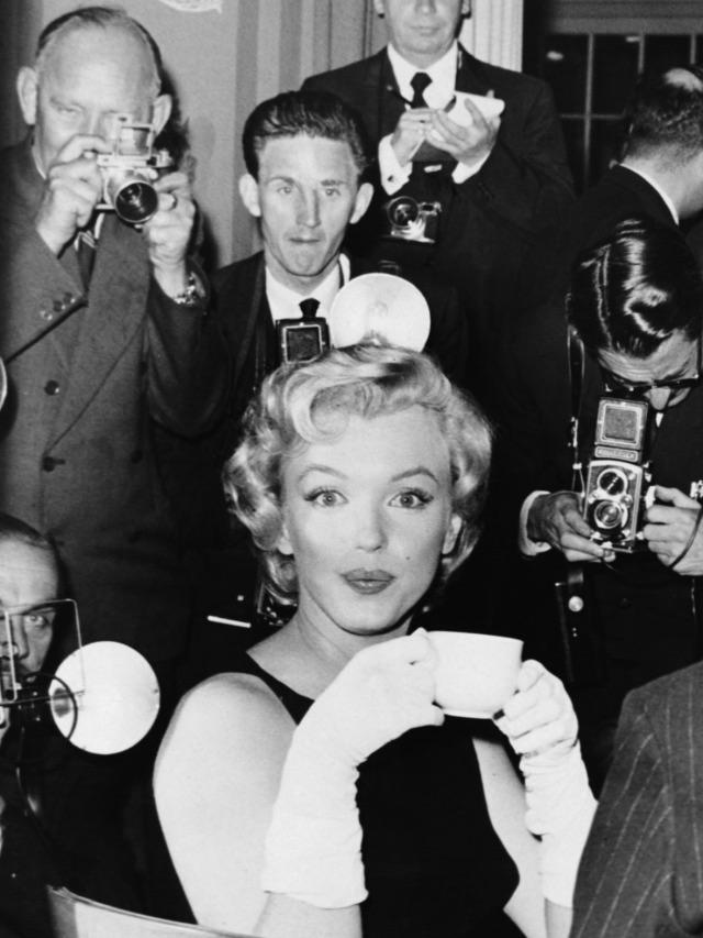 Marilyn Monroe surrounded by journalists at the Savoy Hotel during a press conference on July 15, 1956.jpeg