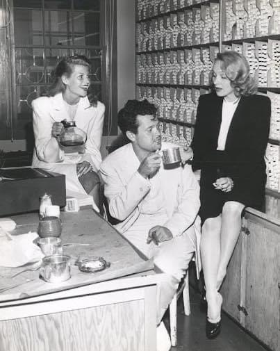 After spending the night bringing bulletins about the end of WWII, Rita Hayworth, Orson Welles, and Marlene Dietrich gather for coffee. (1945).jpeg