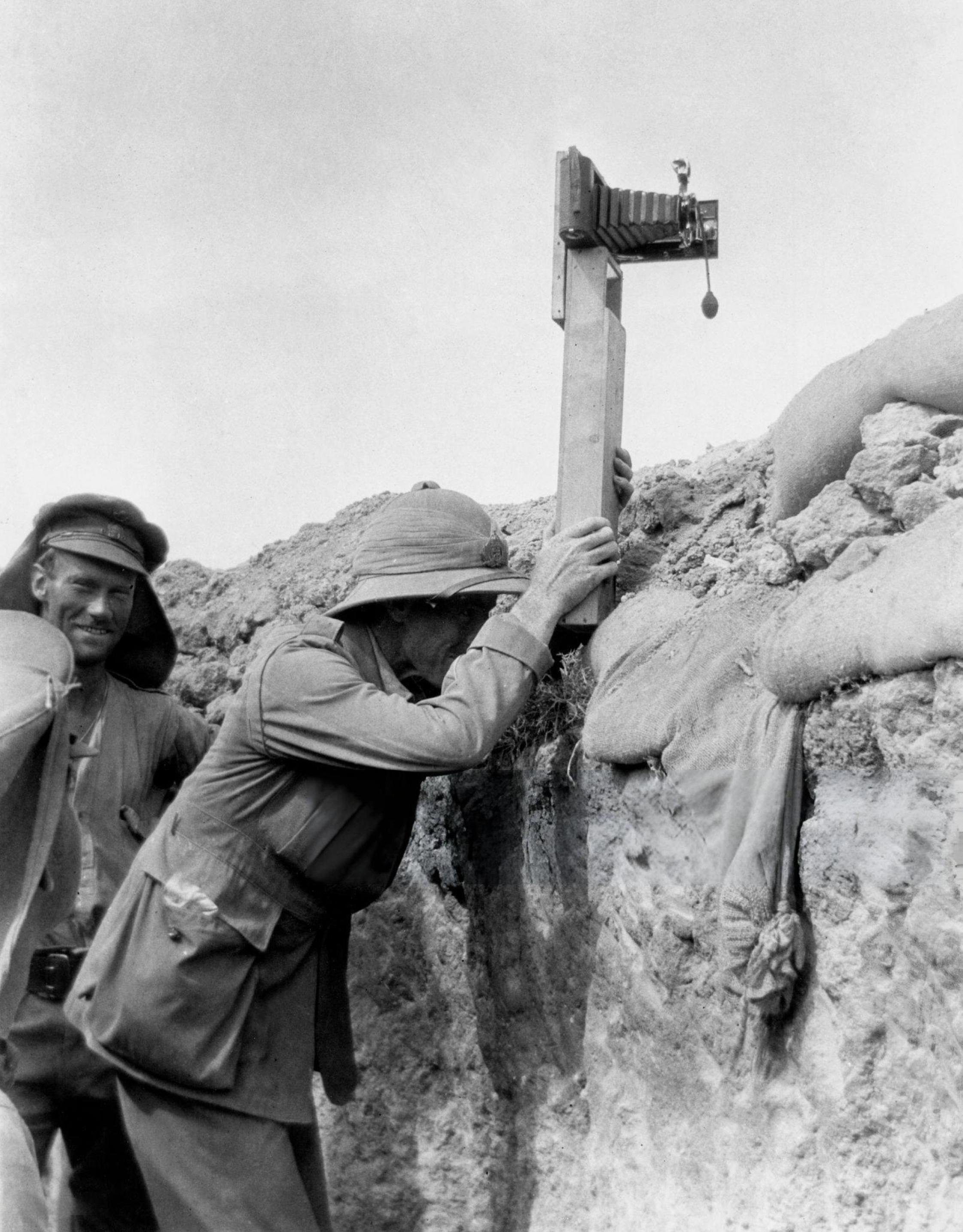 Soldier taking a photograph with a camera attached to a periscope (c1915).jpeg