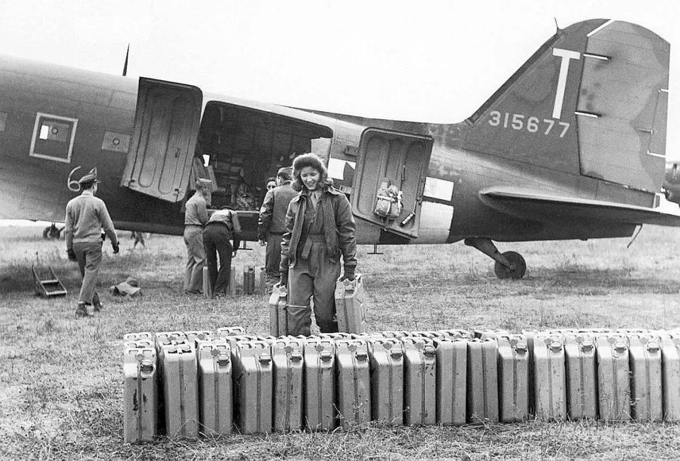 US Army Nurse unloading Jerry cans from a C-47 at Rheims, France, 1944..jpeg