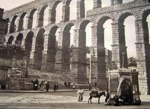Townspeople under the arches of the 1st century Roman Aqueduct in Segovia, Spain, 1911. The aqueduct bridge used no mortar or cement between the 20,400 blocks of stone, which remain standing solidly today.jpeg