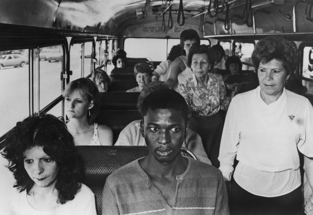 A young black man, in an act of resistance to South Africa's apartheid policies, rides a bus restricted to whites only, in Durban, South Africa, 1980s.jpeg