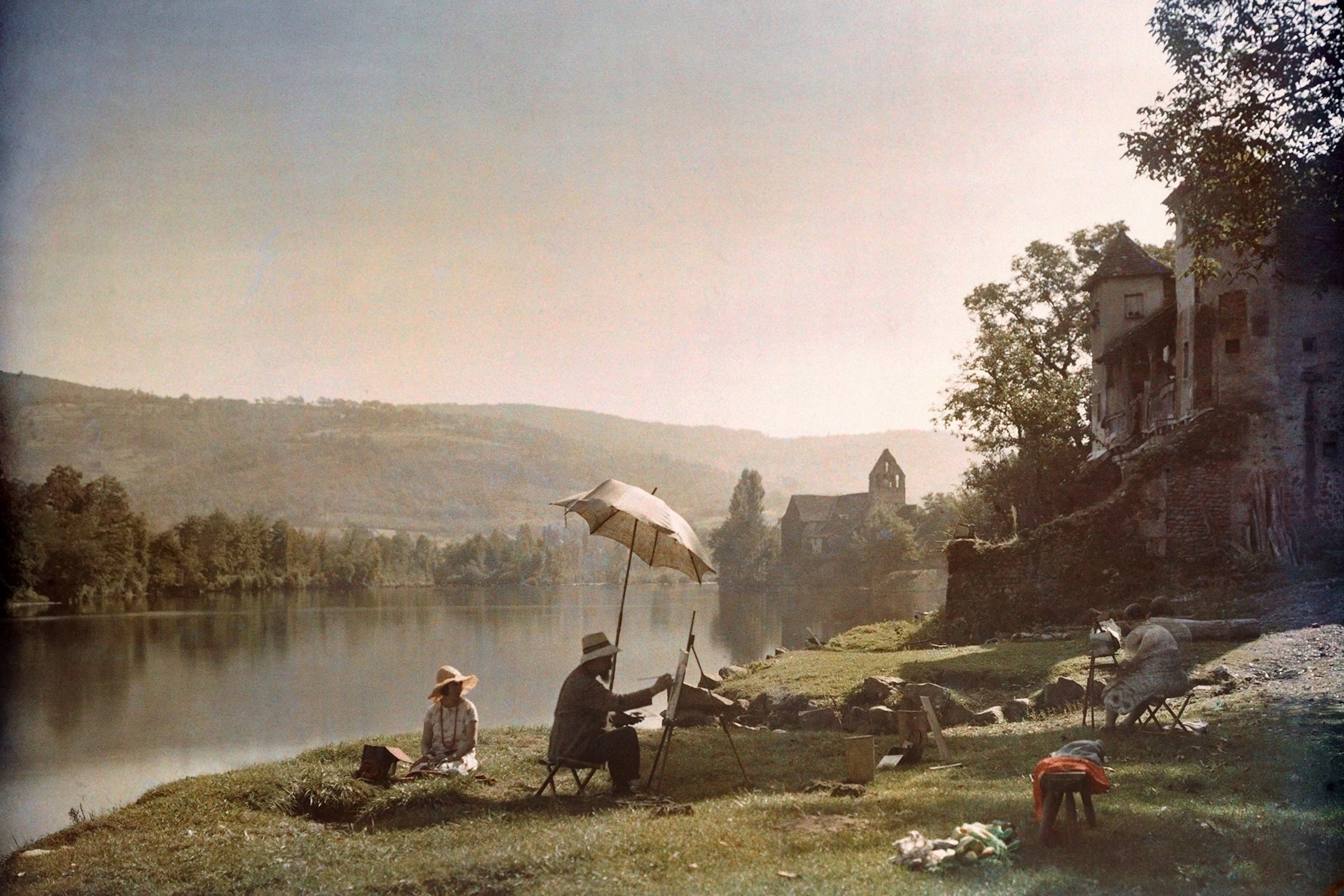 Autochrome photograph of an artist painting and two women by the Dordogne River, France, 1925.JPG