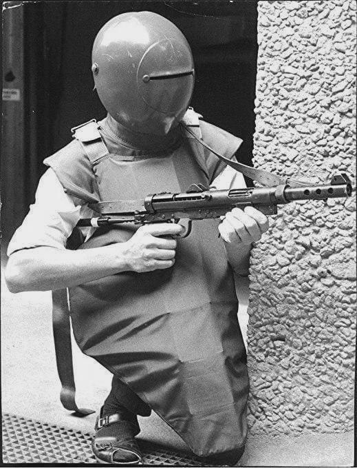 Swedish policeman in an experimental bulletproof armor and helmet and sandals. Södertälje, July 1970.jpeg