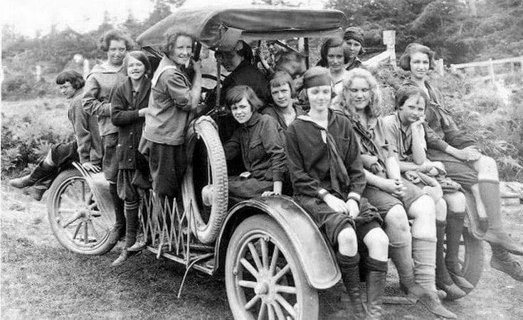 1920 c. Girls piled onto and into a vehicle.jpeg
