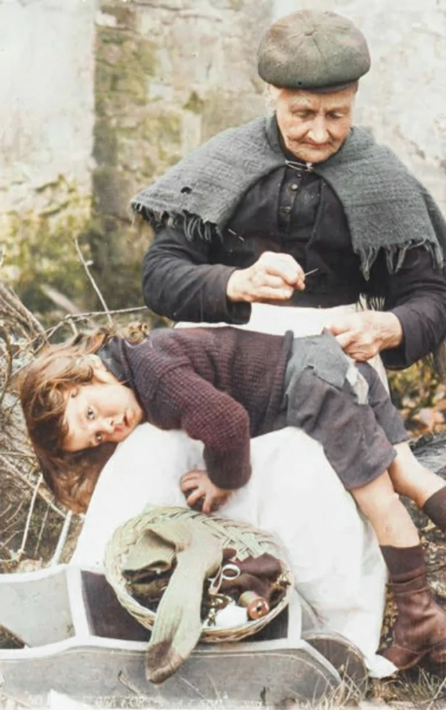 Корнуоллская бабушка зашивает одежду своего внука. Англия, 1907.png