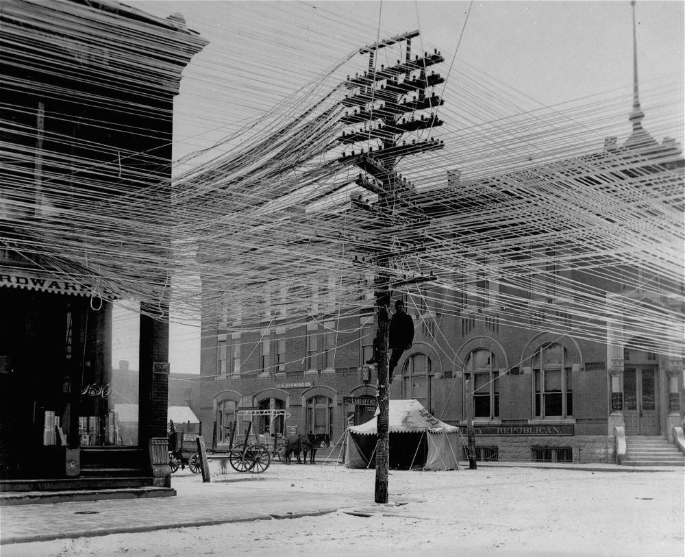 Lineman working on power. Telephone lines at an intersection in Pratt, Kansas, USA, 1911.jpeg