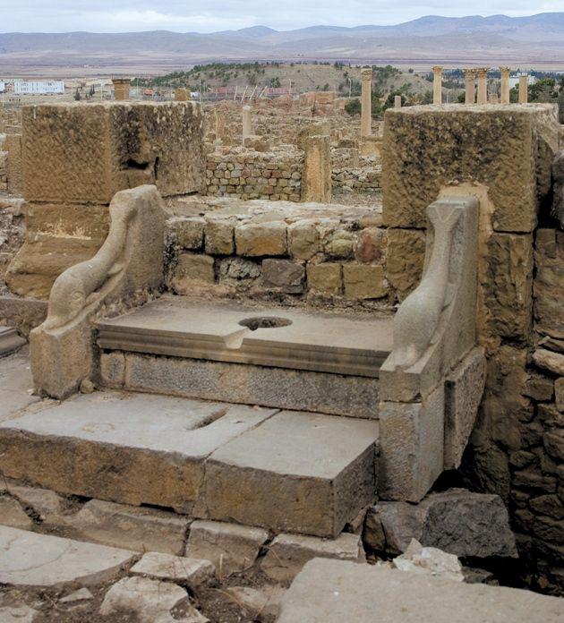 Ancient Roman Public Latrine with Dolphin Decoration in the Ruins of Timgad, Algeria.jpeg