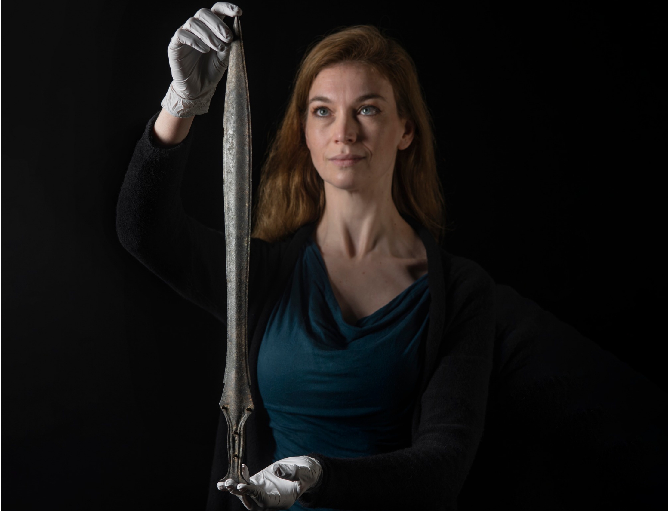 Curator Kate Sumnall holding a Bronze Age sword that was found by a mudlarks on the banks of the River Thames. Museum of London, UK.jpeg