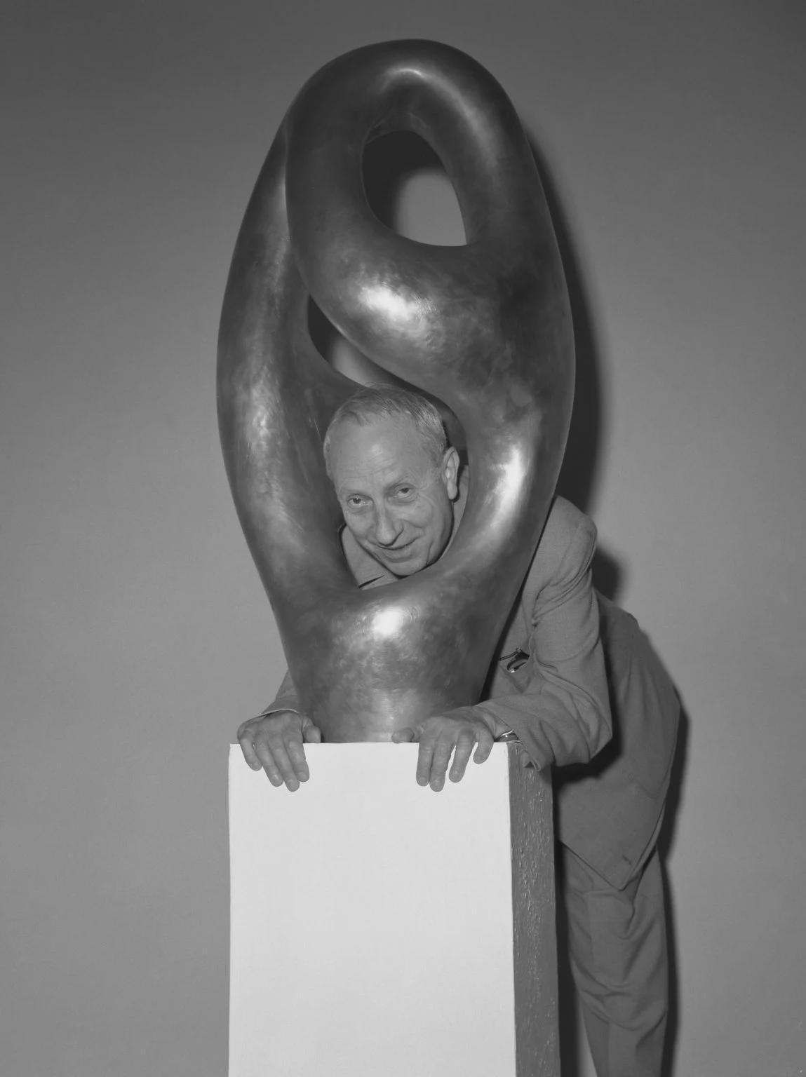 Jean Arp passing his head through one of his Ptolémée sculptures, Art Biennale, Venice (1954).jpeg