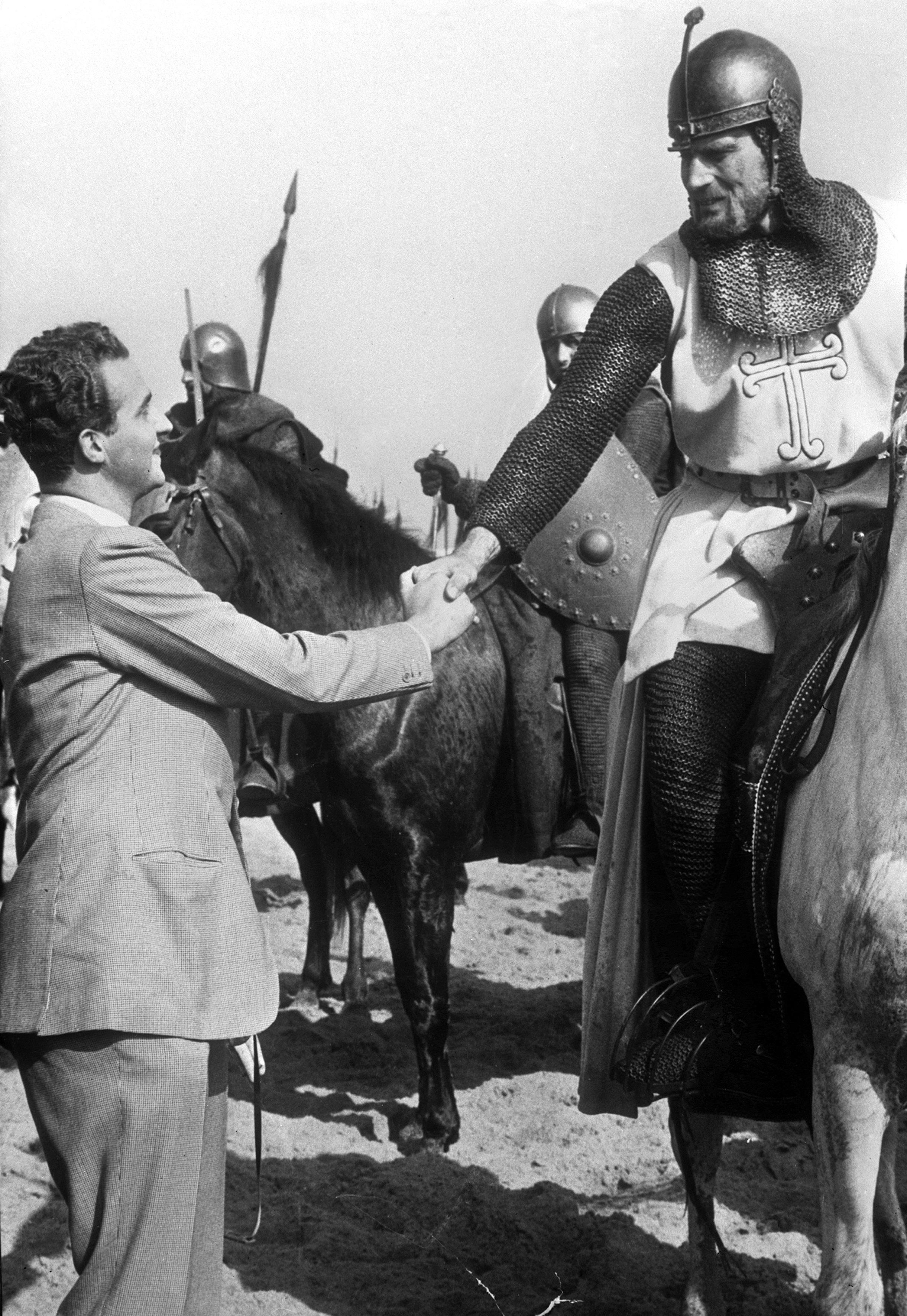 Juan Carlos I (then Prince of Spain) shakes hands with Charlton Heston during the filming of El Cid (1961).jpeg