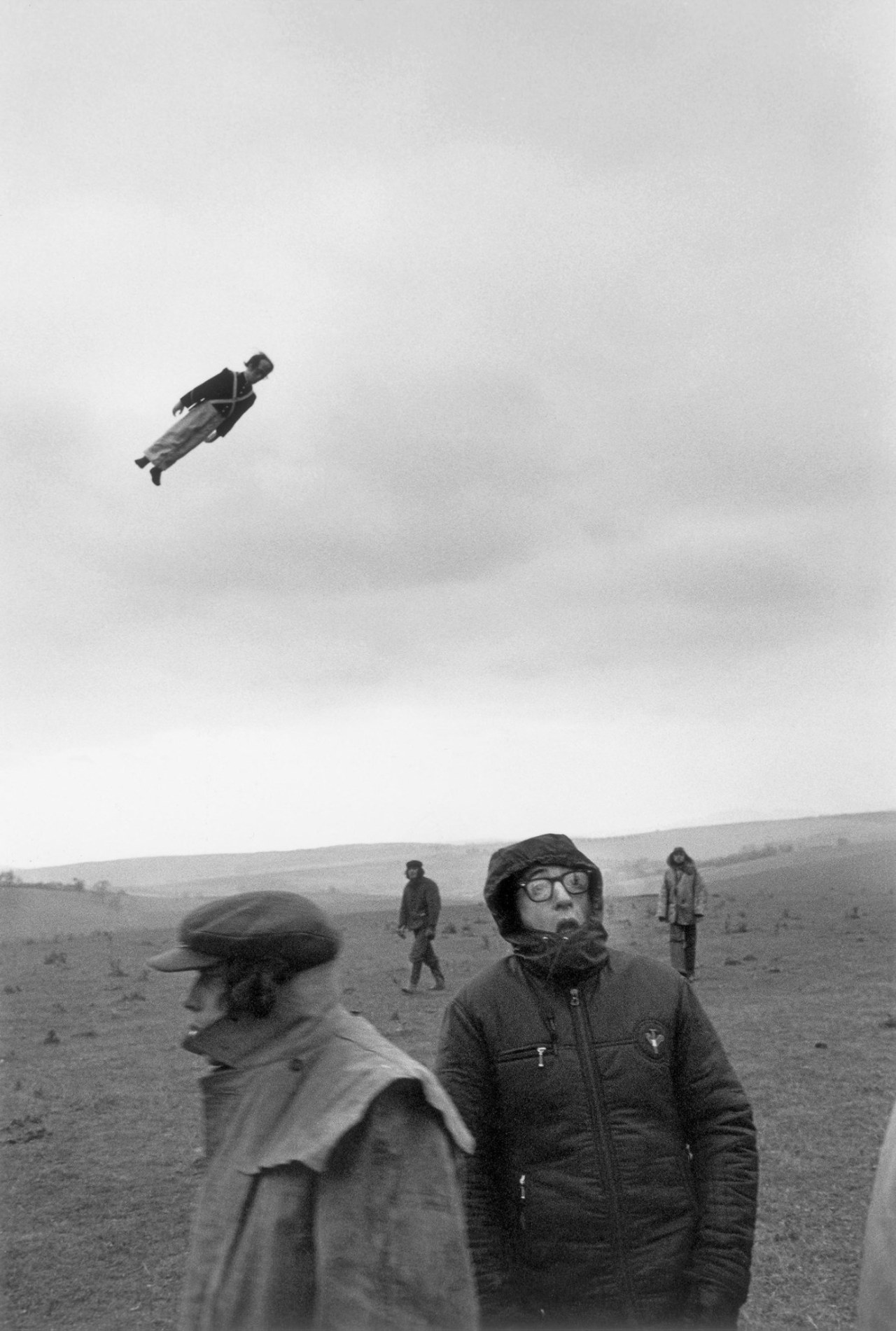 Woody Allen on a shoot for ‘Love and Death’, set during the Napoleonic Wars. Behind him, a dummy soldier flies through the air, supposedly fired from a cannon. Circa 1974.jpg