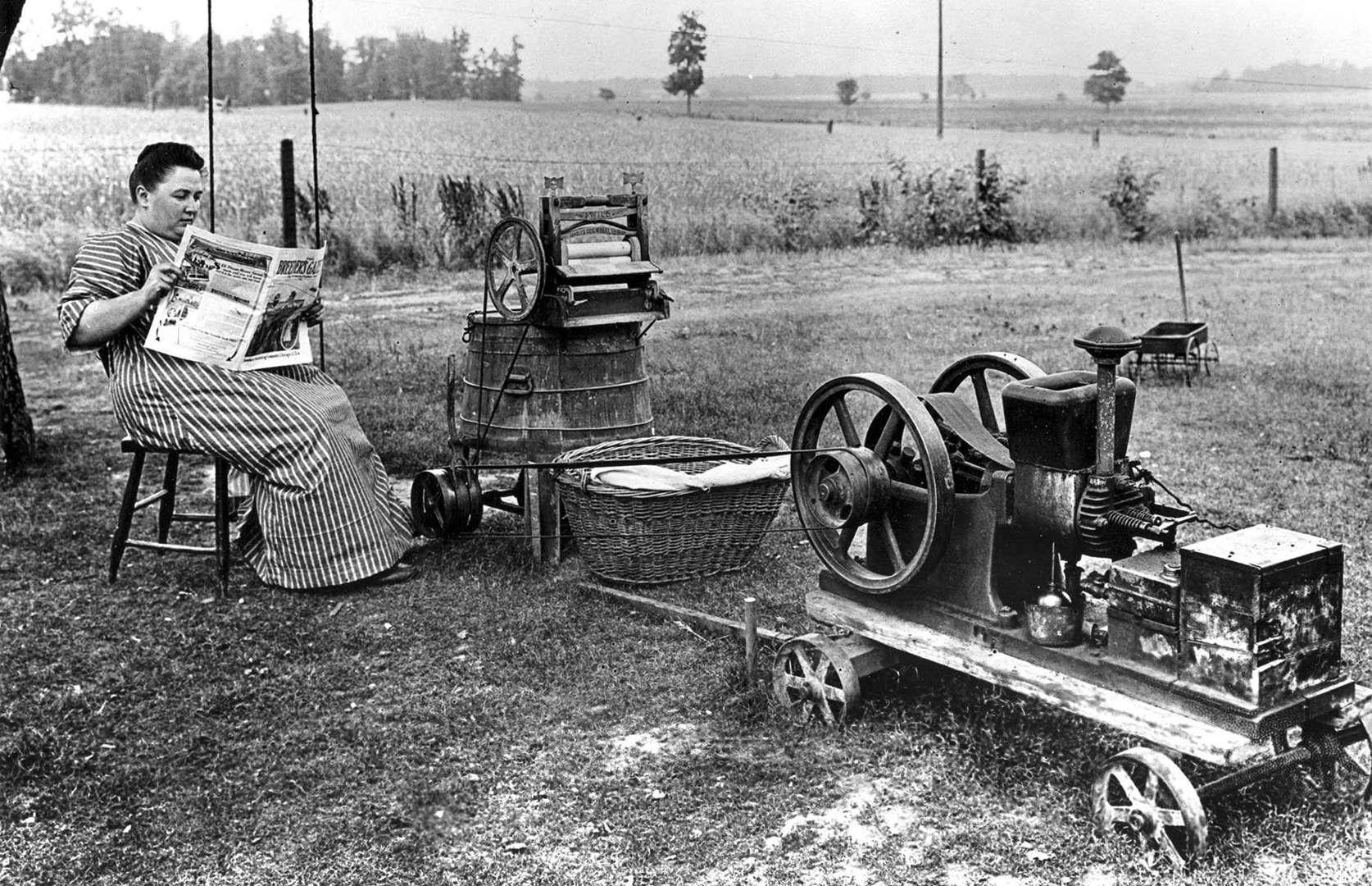 Lady reading the paper while her Gas-Powered Washing Machine does it's work. 1914.jpeg