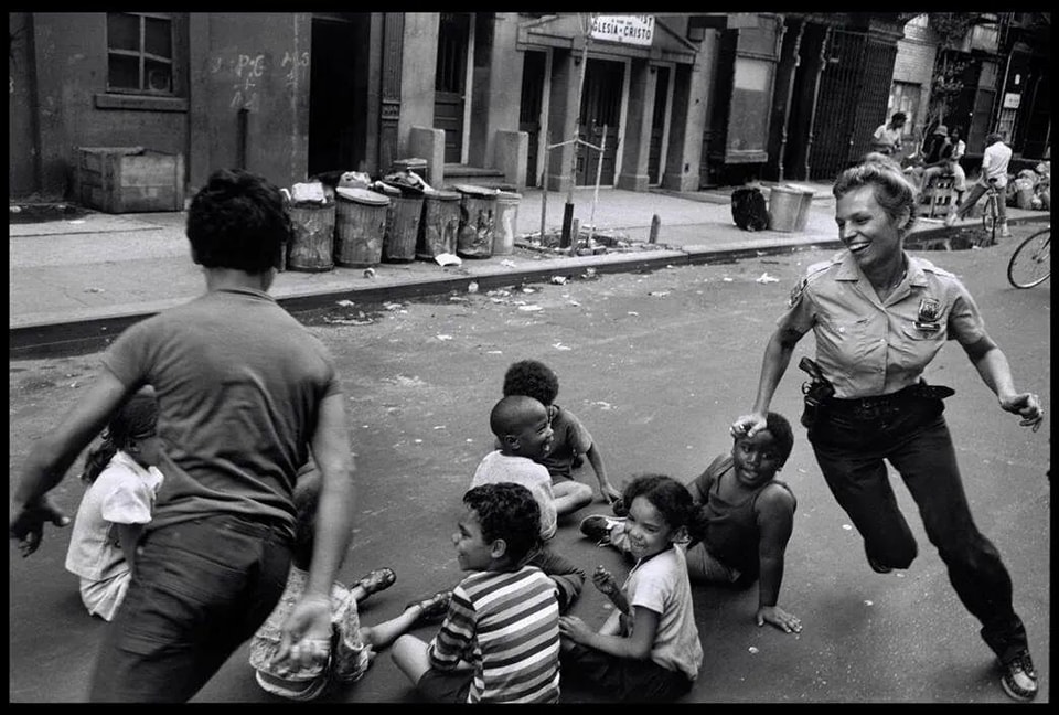 Police officer playing with children, Harlem (1978).jpg